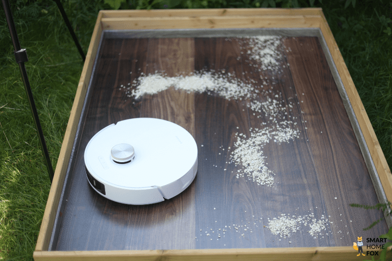 Yeedi Cube reinigt beim Saugtest Haferflocken auf einem Hartboden.